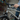 Close-up of a child's hand gripping the handlebar brake lever of a silver kids' bike with reflector